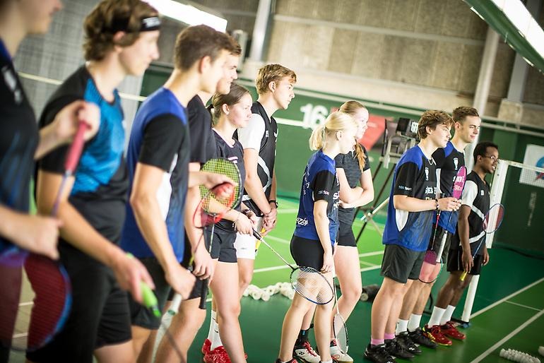 Unga badmintonspelare får en instruktion.