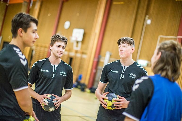 Unga handbollsspelare står och pratar med varandra.